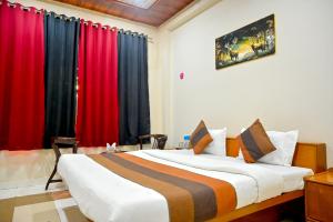 a bedroom with a large bed with red curtains at Hotel Dhola Maru in Kota +41 photos