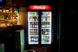 a cocacola cooler in a bar with many drinks at Hotel Dhola Maru in Kota