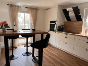 a kitchen with a table and stools in a kitchen at Ferienwohnung am Reichenbach in Hechingen
