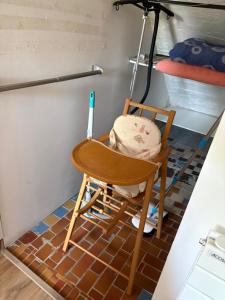 a wooden chair sitting on a tiled floor in a room at Au frais studio calme proche aéroport et parc exposition Jade in Saint-Jacques-de-la-Lande