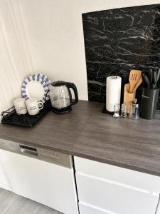 a counter top with mugs and utensils on it at Workers House in Bockenem +4 photos