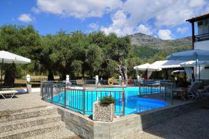 a swimming pool in a resort with tables and umbrellas at Hotel Sylvia in Koinyra