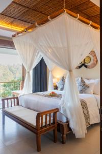 a bedroom with two beds and a canopy bed at The Compass Rose Valley in Ubud +102 photos