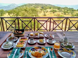 a breakfast table with breakfast foods on a wooden deck at Pakamisa Private Game Reserve in Pongola
