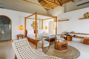 a bedroom with a canopy bed and a table and chairs at Casa Rodi Zanzibar in Jambiani +74 photos