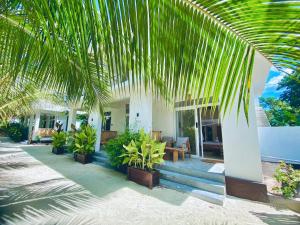 a house with palm trees and a table and chairs at Balungi Boutique Hotel in Uroa