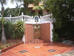 a gate to a house with a white fence at Romervic vacational apartments in Juangriego