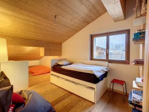 ein Schlafzimmer mit einem Bett in einem Zimmer mit Fenster in der Unterkunft Asters 8 in Verbier