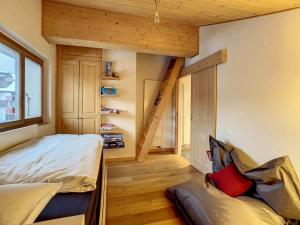 ein kleines Schlafzimmer mit einem Bett und einer Treppe in der Unterkunft Asters 8 in Verbier