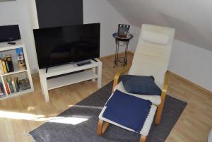 a living room with a chair and a television at Wichmann, Ursula & Axel in Schönberg