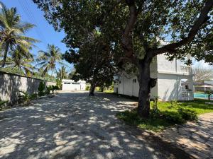 a street with trees and a white building at M&H Boutique Hotel in Mombasa