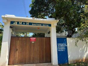 a wooden garage door with a sign on it at M&H Boutique Hotel in Mombasa