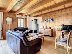 a living room with leather furniture and wooden walls at Laiterie 1 in Verbier