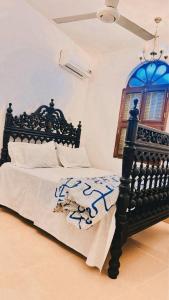 a bedroom with a black bed and a window at ZANZInest Apartment in Kituoni