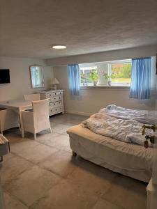 a bedroom with a bed and a table and windows at Oddevej 20 Skagen in Skagen