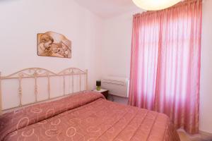 カンネートにあるCasa Francesca Cannetoのベッドルーム1室(ピンクのベッドカバー付)