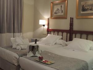Habitación de hotel con 2 camas y bandeja de comida en Parador de Zamora, en Zamora