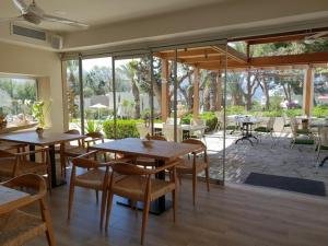 a restaurant with tables and chairs and a patio at Eleni Village & Suites in Amoudara Herakliou