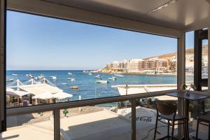 a view of the ocean from a balcony at Electra Residence - Luxury Central Beach View Studio Apartment in Marsalforn