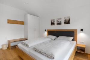 a large white bed in a room with white walls at Oberstarzerhof in Barbiano