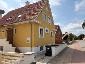 a yellow house with a grill on a street at Oddevej 20 Skagen in Skagen