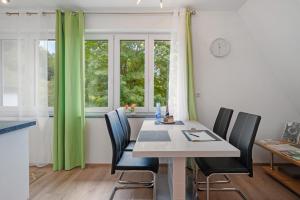 a dining room with a table and chairs and a window at Haus Burgblick in Badenweiler