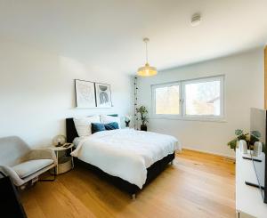 a bedroom with a large bed and a chair at 3S Holiday Home in Traunstein