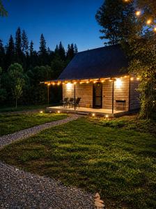 a cabin lit up at night with lights at Тиша біля річки in Izki