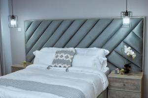 a bedroom with a large bed with a metal headboard at Pomona Palm Villa in Harare