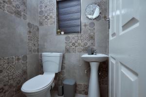 a bathroom with a toilet and a sink at Pomona Palm Villa in Harare +7 photos