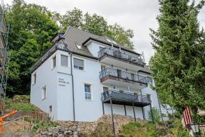 a white house with balconies on a hill at Haus Burgblick in Badenweiler