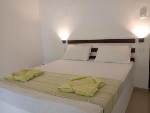 a white bed with two yellow pillows on it at All View Safari Cottage in Timbulketiya +56 photos