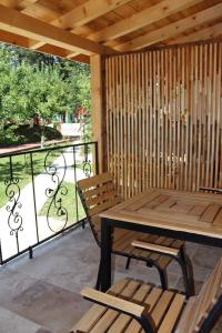 a patio with a wooden table and chairs and a balcony at La Brazi by BMD in Vulcan