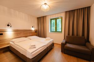 a hotel room with a bed and a chair at PÚŠŤ rekreačné stredisko in Prievidza +44 photos