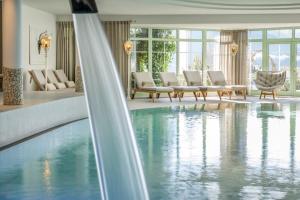 a hotel lobby with a swimming pool and chairs at Hotel Sonnenhof in Grän