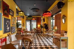 a restaurant with yellow walls and tables and chairs at Habitat Suites - Modern Apartments with Terraces and Free Parking in Craiova