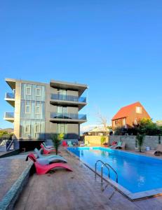 a hotel with a swimming pool in front of a building at ,,KaKalo'' Apartments in Kobuleti