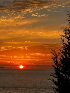 a sunset over the ocean with the sun in the sky at Bluemoon Suites Sarande in Sarandë