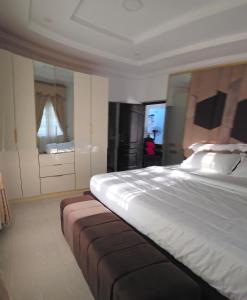 a bedroom with a large bed and a large mirror at MDY Apartments in Ile-Ife