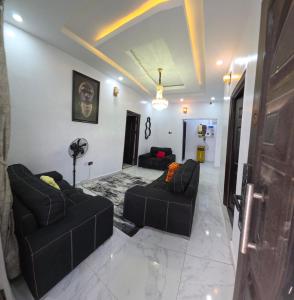 a living room with two black couches in a room at MDY Apartments in Ile-Ife