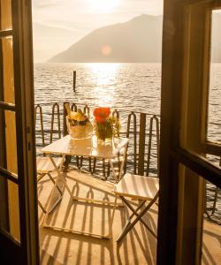 een tafel en stoelen op het dek van een cruiseschip bij Casa Dante in Sale Marasino