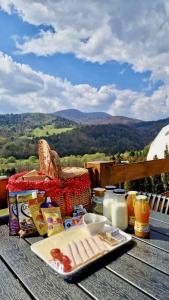 a picnic table with a plate of food and milk at Glamping Pod Hradom súkromné jacuzzi a sauna in Bardejov