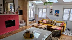 a living room with a yellow couch and a red fireplace at 1860 Bordeaux - Lormont house in Lormont