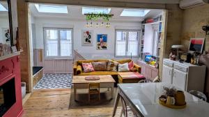 a living room with a yellow couch and a kitchen at 1860 Bordeaux - Lormont house in Lormont