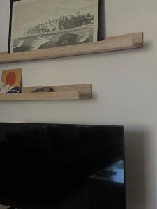 a flat screen tv sitting on top of a wall at Squarehouse Apartment Prishtina in Prishtinë