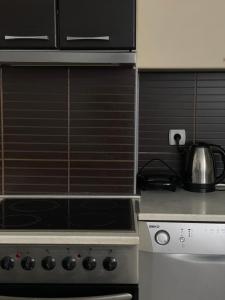 a stove top oven with a tea kettle on top of it at Squarehouse Apartment Prishtina in Prishtinë