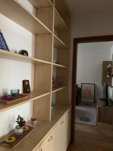 a living room with wooden shelves and a mirror at Squarehouse Apartment Prishtina in Prishtinë