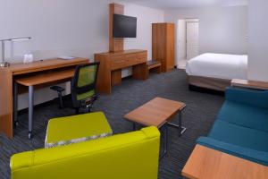 a hotel room with a bedroom with a bed and a desk at Holiday Inn Express & Suites Lexington Midtown - I-75, an IHG Hotel in Lexington