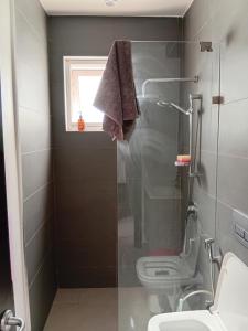 ein Badezimmer mit Dusche, Toilette und Fenster in der Unterkunft ZanziBeach Hotel in Jambiani