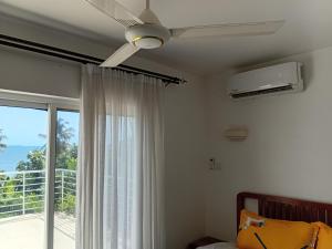 ein Schlafzimmer mit Deckenventilator und Fenster in der Unterkunft ZanziBeach Hotel in Jambiani